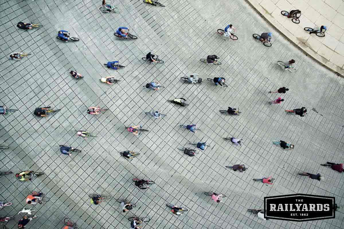 Overhead view of a large group of cyclists. Learn more about the benefits of bike friendly communities.