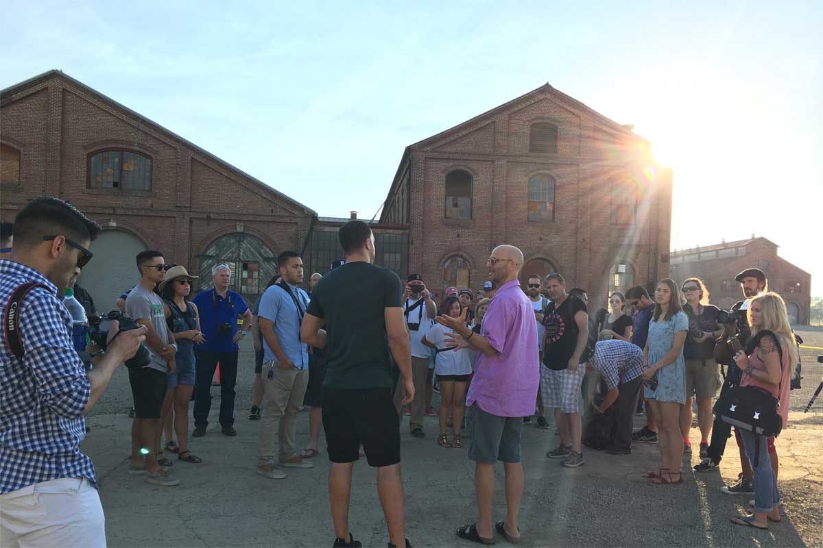An image of a group of people gathered in front of the Railyards' historic buildings. Learn more the plans for housing at the Railyards.